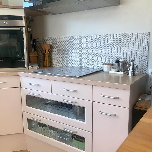 Realización de un cliente: salpicadero de pequeños hexágonos blancos en una cocina